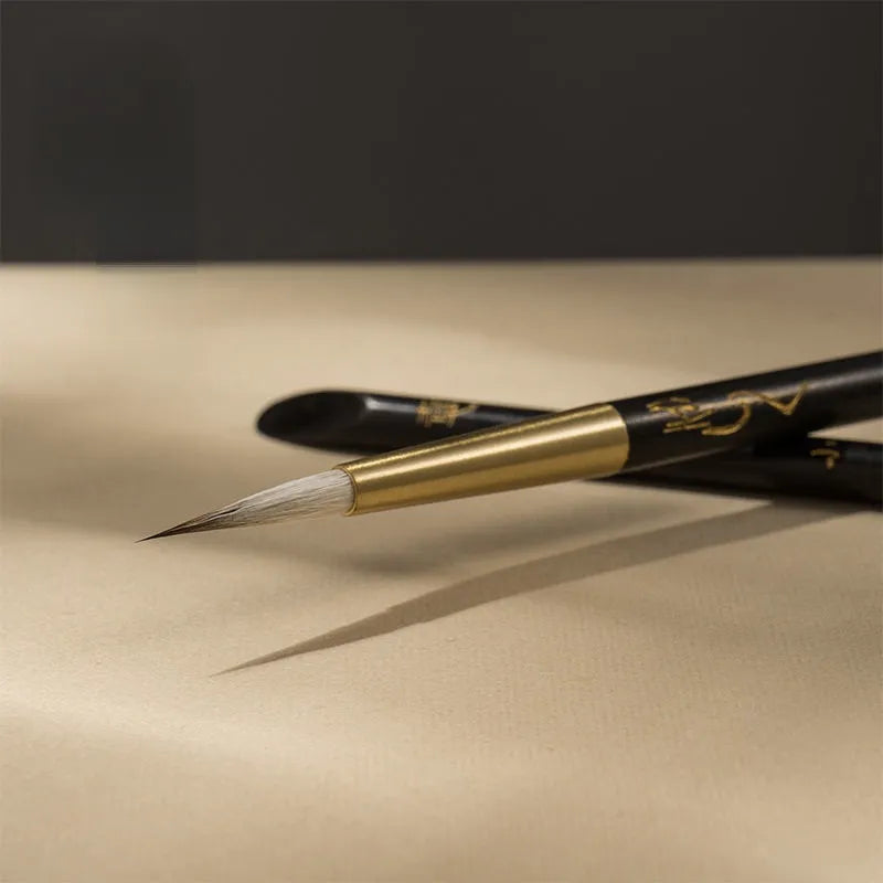Pincel de linha fina para caligrafia com porta-pincel de ébano e latão.
Detalhe do pelo macio de lã e design ergonômico do pincel de caligrafia.
Pincéis de caligrafia em tamanhos pequeno e grande para escrita precisa.