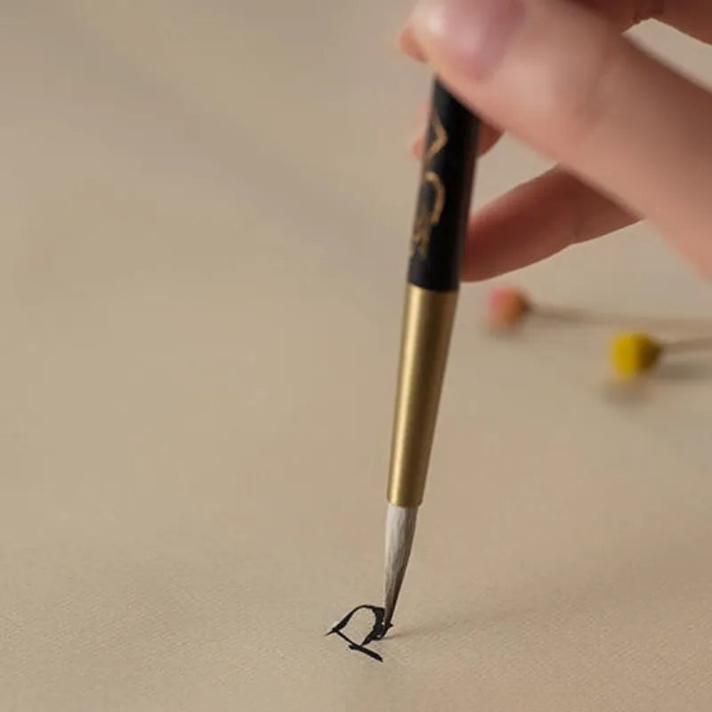 Pincel de linha fina para caligrafia com porta-pincel de ébano e latão.
Detalhe do pelo macio de lã e design ergonômico do pincel de caligrafia.
Pincéis de caligrafia em tamanhos pequeno e grande para escrita precisa.