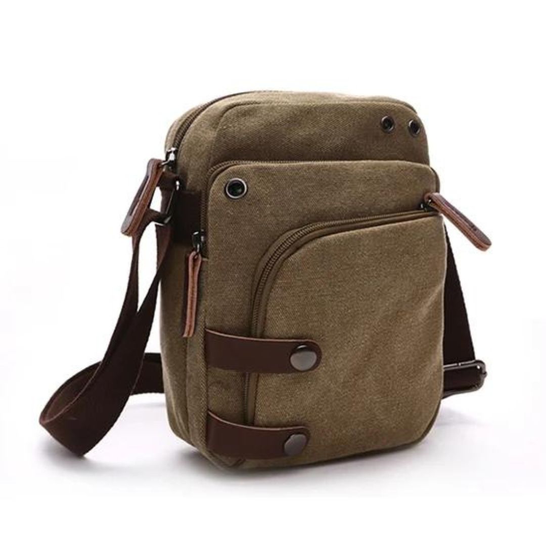 Bolsa de Ombro Masculina, confeccionada em lona resistente, sendo versátil para diversas ocasiões. Seu interior possui vários bolsos, incluindo um específico para celular, além de um espaçoso compartimento com fechamento em zíper. Com um estilo vintage, essa bolsa é perfeita para aqueles que buscam praticidade e estilo.