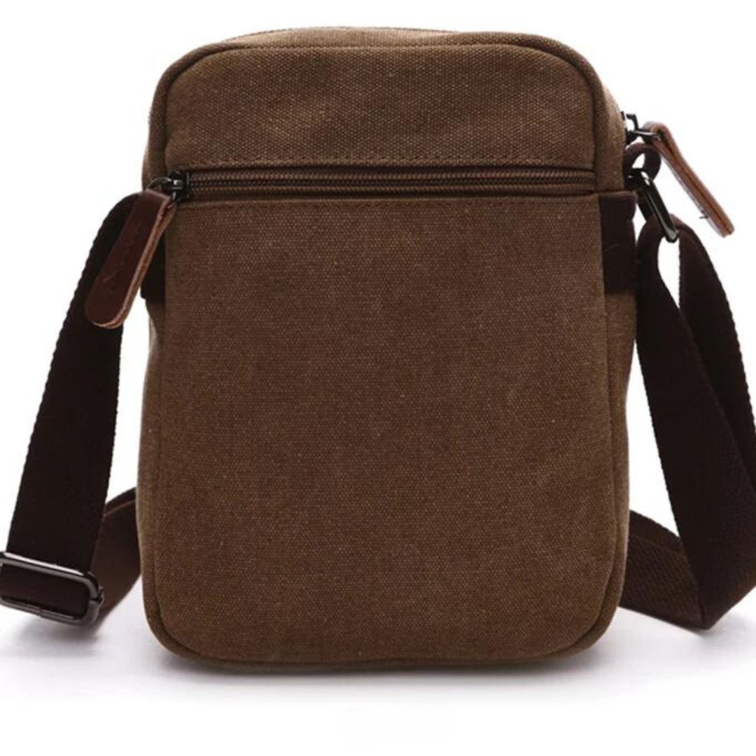 Bolsa de Ombro Masculina, confeccionada em lona resistente, sendo versátil para diversas ocasiões. Seu interior possui vários bolsos, incluindo um específico para celular, além de um espaçoso compartimento com fechamento em zíper. Com um estilo vintage, essa bolsa é perfeita para aqueles que buscam praticidade e estilo.