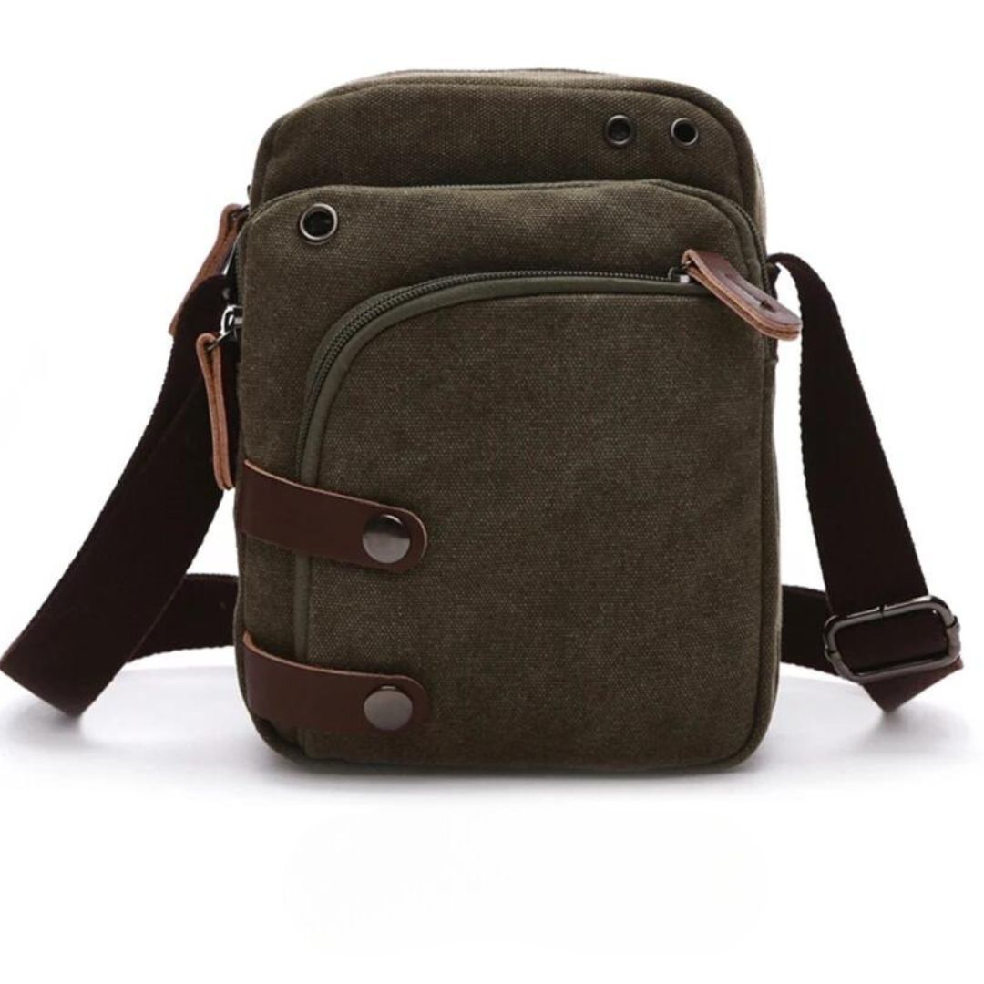 Bolsa de Ombro Masculina, confeccionada em lona resistente, sendo versátil para diversas ocasiões. Seu interior possui vários bolsos, incluindo um específico para celular, além de um espaçoso compartimento com fechamento em zíper. Com um estilo vintage, essa bolsa é perfeita para aqueles que buscam praticidade e estilo.