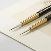 Pincel de linha fina para caligrafia com porta-pincel de ébano e latão.
Detalhe do pelo macio de lã e design ergonômico do pincel de caligrafia.
Pincéis de caligrafia em tamanhos pequeno e grande para escrita precisa.